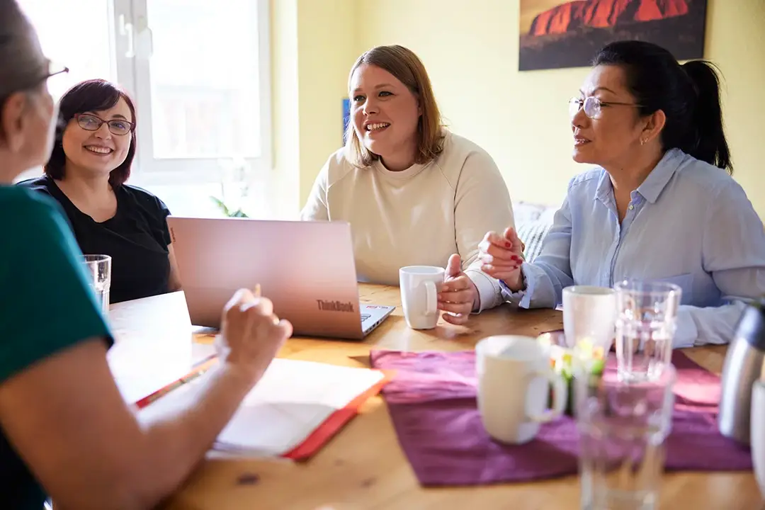 Verschiedene Frauen unterhalten sich am Tisch. Finde hier Informationen zu den Ausbildungen bei der Lebenshilfe Herford.